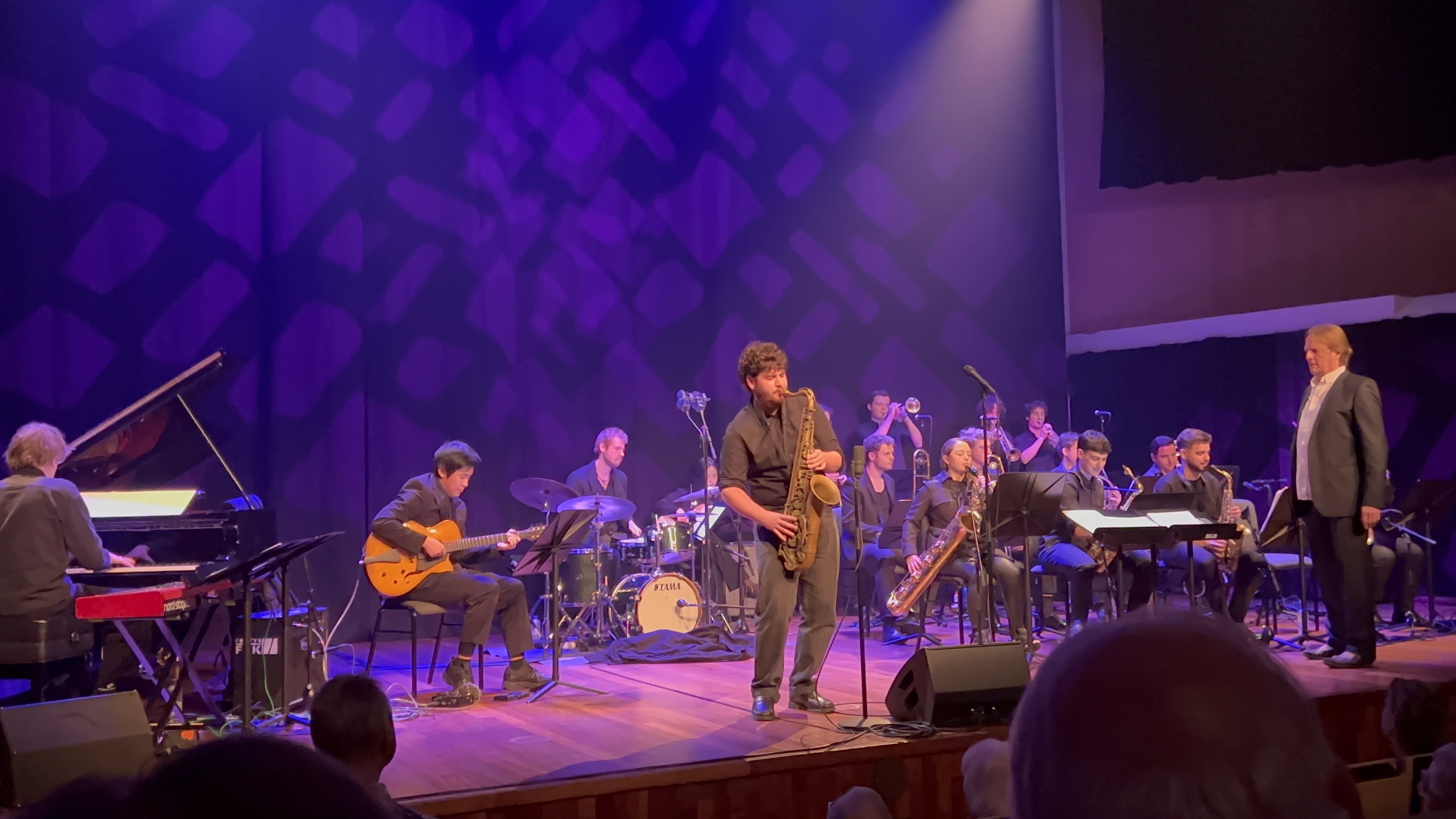 Zhanpeng Yang playing saxophonist's solo spotlight with the Fontys Bigband on stage