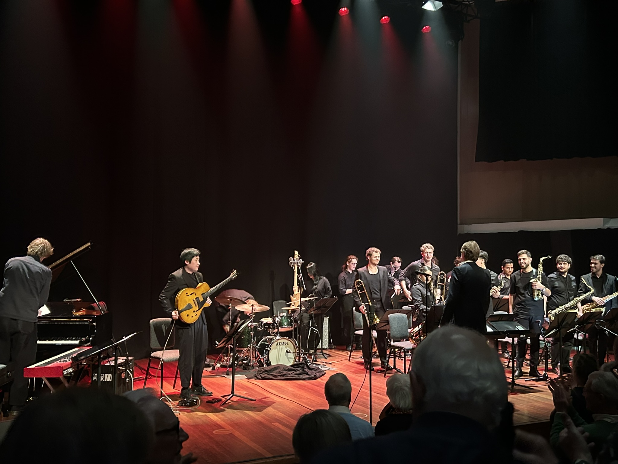 Fontys Bigband musicians on stage between pieces, smiling