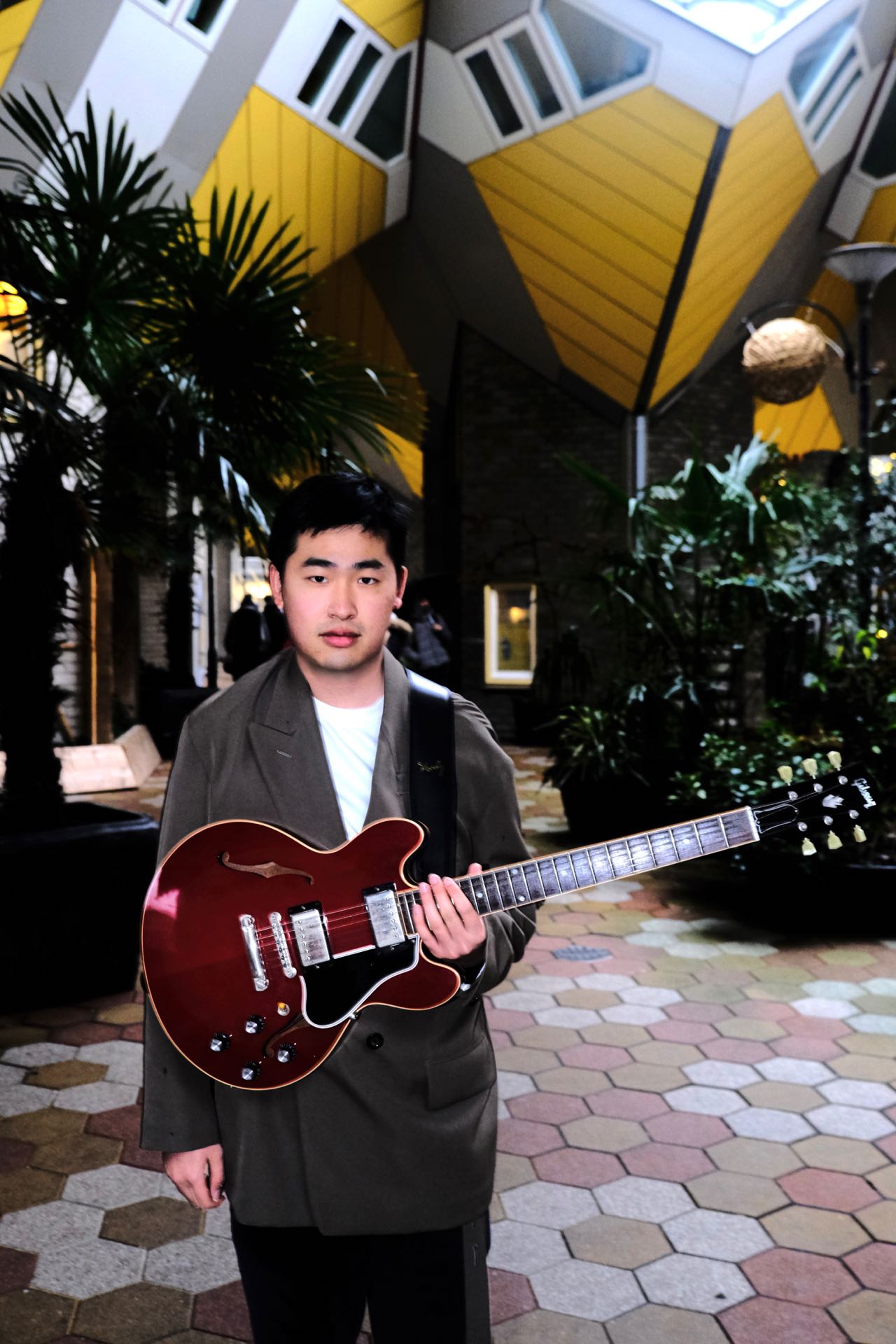 Zhanpeng Yang holding a hollow-body electric guitar